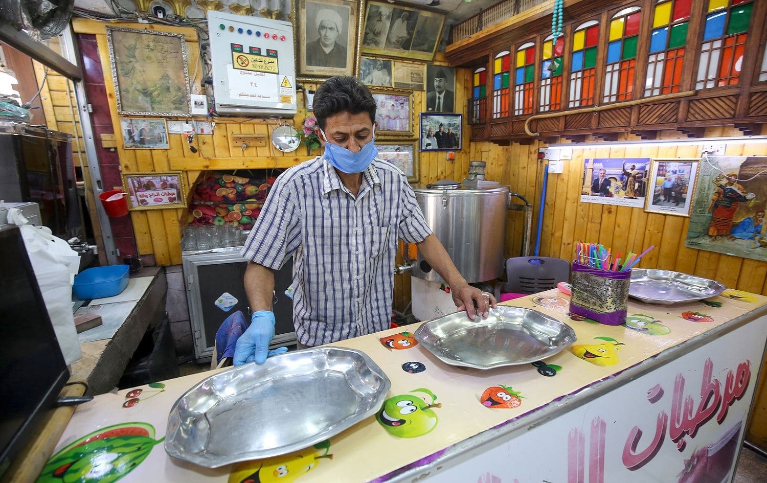 An Iraqi man, wearing protective equipment, prepares a juice order at his shop in the Iraqi capital Baghdad on April 17, 2020. Photo: Ahmad Al-Rubaye/ AFP