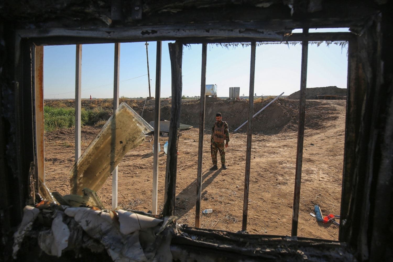 An Iraqi fighter with the Hashed al-Shaabi (Popular Mobilisation Forces) inspects the site of the Islamic State (IS) group attack, a day earlier, on a unit of the paramilitary force in Mukaishefah on May 3, 2020. Photo: Ahmad Al-Rubaye/ AFP