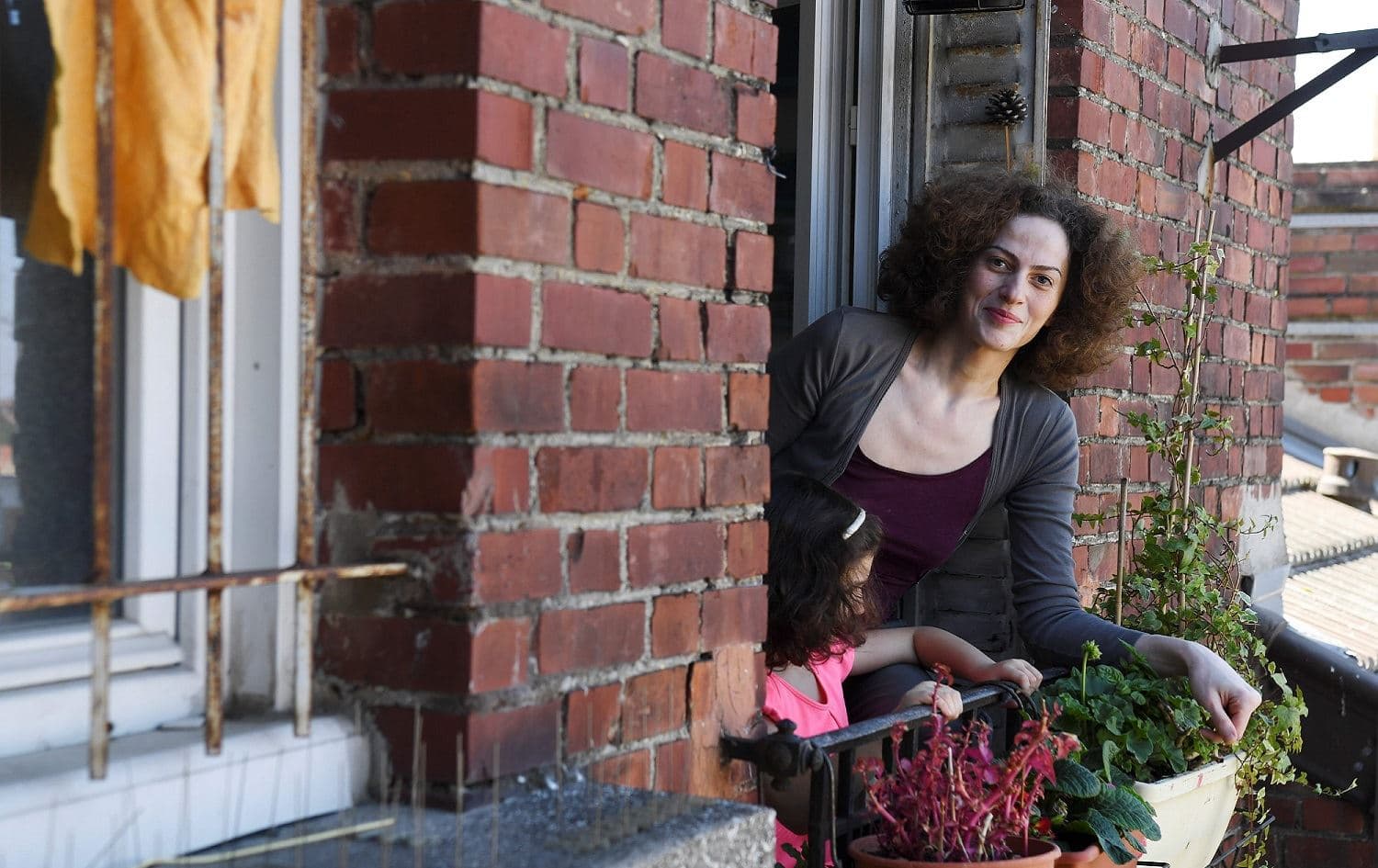 Syrian refugee Dunia poses at her apartment window in Clamart near Paris, April 26, 2020. Photo: Alain Jocard / AFP