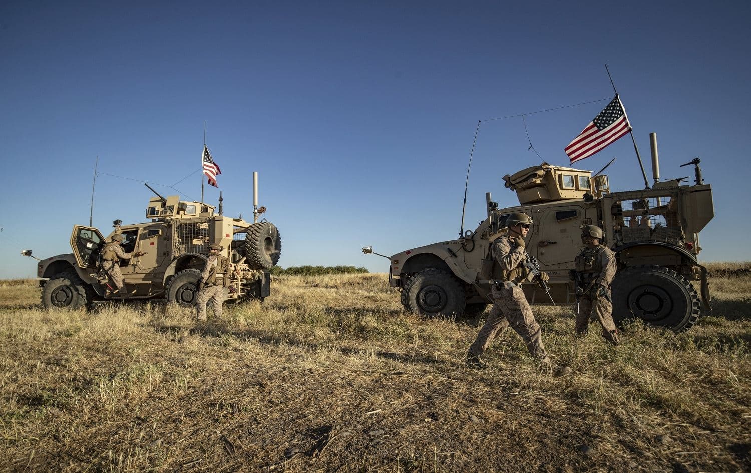 A US military convoy makes a stop in the western countryside of the northeastern Syrian town of al-Malikiyah (Derik), as it patrols Kurdish towns near the border with Turkey, on June 7, 2020. Photo: Delil Souleiman/ AFP