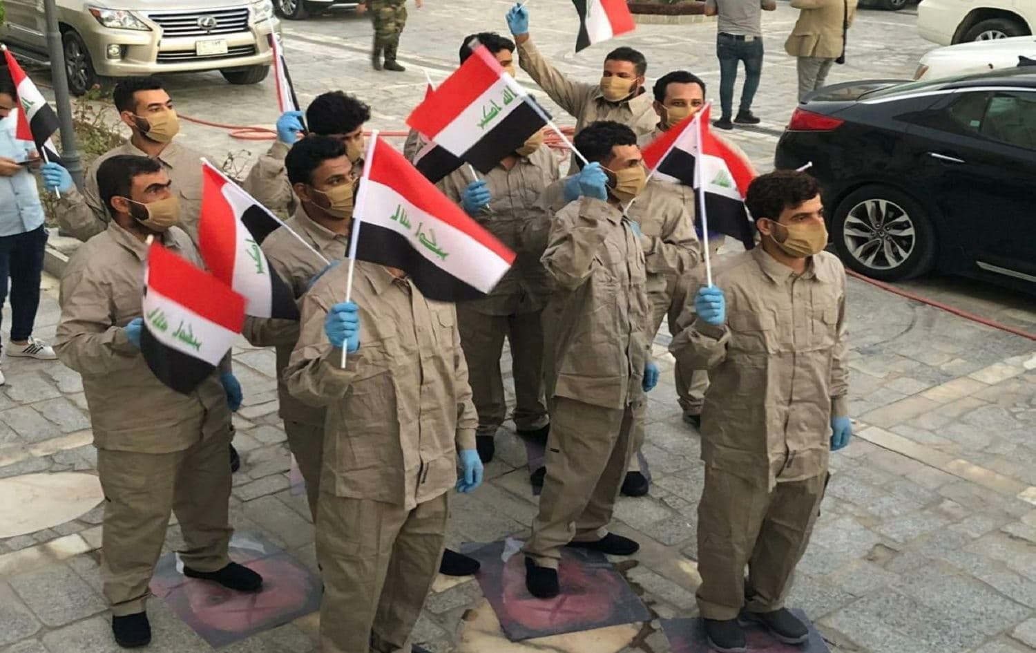 Kataib Hezbollah fighters pictured in Baghdad on June 29, 2020 stand on photos of Iraqi PM Mustafa al-Kadhimi after being released by Iraqi counter-terrorism forces. Photo: social media