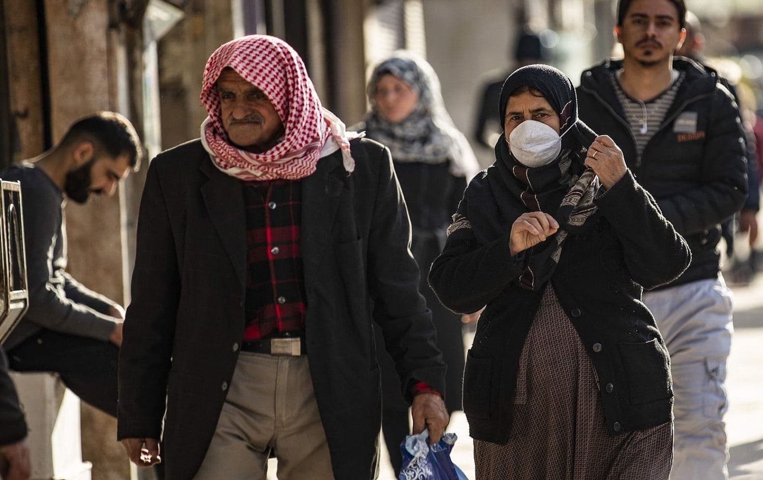 A woman wearing a protective mask walks along a street in Qamishli, northeast Syria on March 22, 2020. File photo: Delil Souleiman/AFP