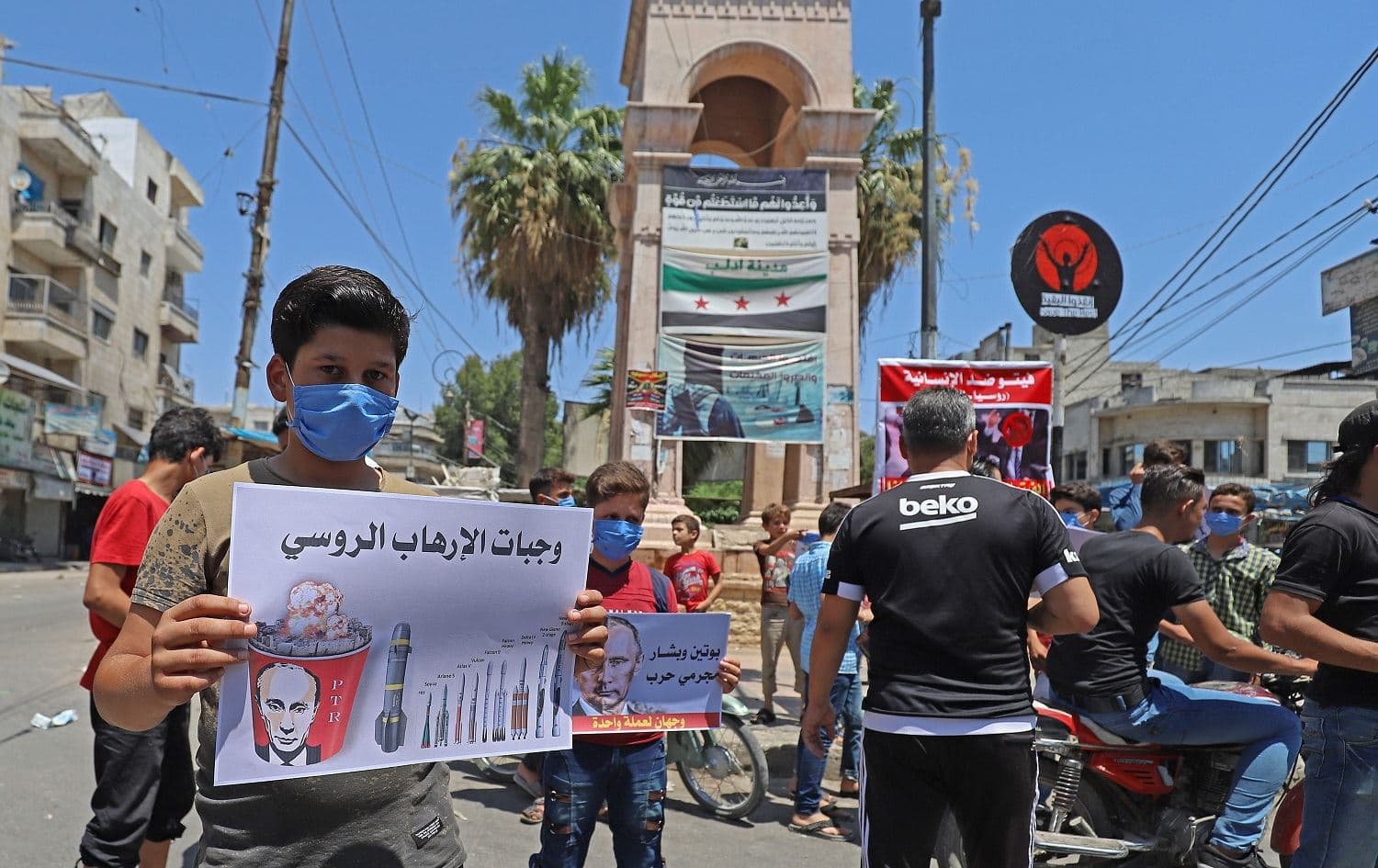 Syrian protesters in the city of Idlib carry placards expressing their opposition to regime ally Russia's attempt to reduce cross-border aid to millions in the northwest of the war-torn country, on July 10, 2020. Photo: Abdulaziz Ketaz/AFP