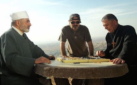 Kurdish-American filmmaker Jano Rosebiani (center) with actors Ghazi Ghefur (priest) and Ismail Salih (Mella Issa). Photo courtesy of Evini Films
