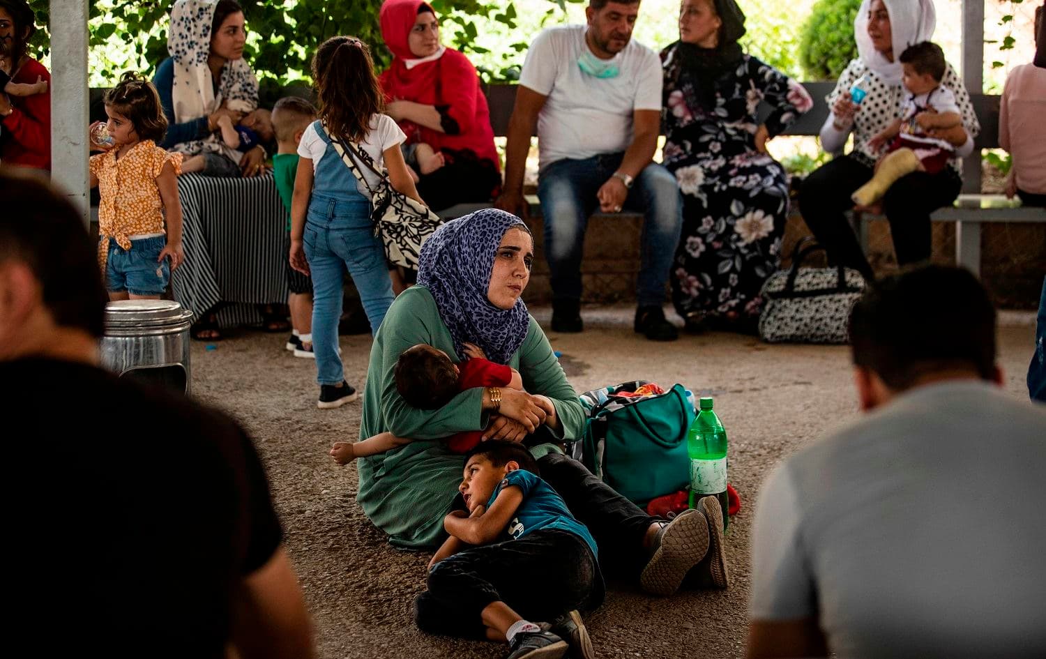 A Syrian woman, who was stranded following the closure of border due to the COVID-19 pandemic, waits with her children to cross into Iraqi Kurdistan from the Syrian side of the Semalka border crossing in northeastern Syria on July 29, 2020. Photo: Delil Souleiman/AFP