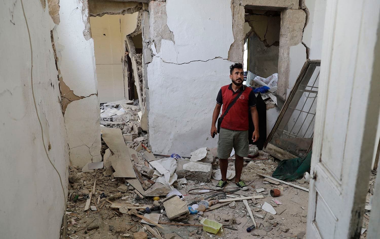 A Syrian national checks a heavily damaged building in Beirut's Karantina neighbourhood on August 19, 2020. Photo: Joseph Eid/AFP