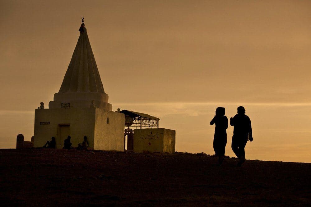 Women visit a Yezidi shrine overlooking Khanke Camp for the internally displaced in Dohuk at sunset on May 18, 2016. File photo: Maya Alleruzzo / AP
