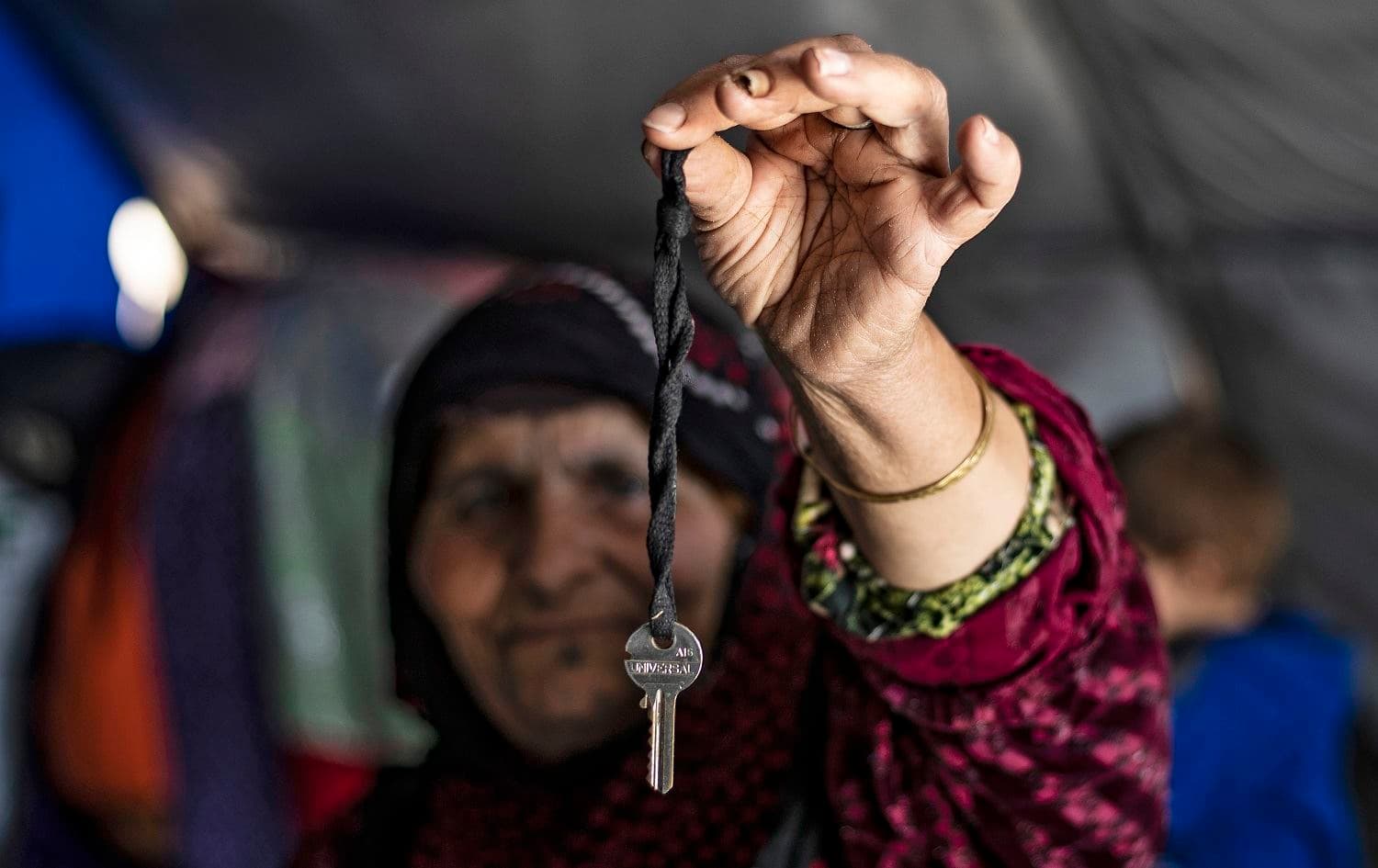 Qamra Ali, a 65-year-old woman who was displaced with her family from the countryside of Ras al-Ain, holds the key to the door of her old house as she stands in a tent at the Washukanni camp for the internally displaced near the town of Tuwaynah, west of Syria's northeastern city of Hasakah on October 8, 2020. Photo: Delil Souleiman / AFP
