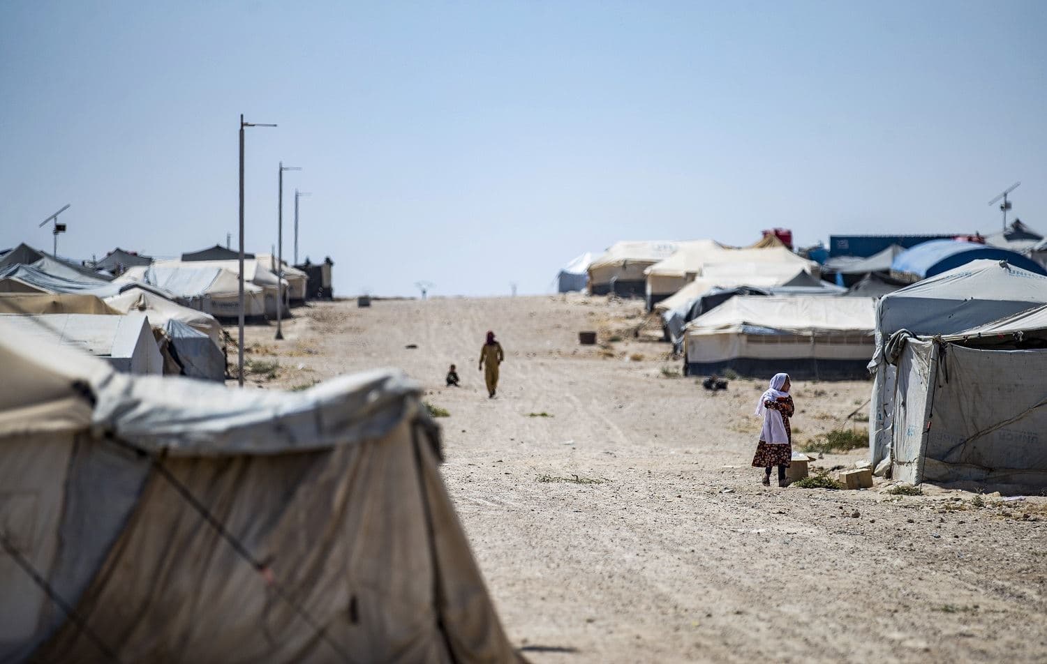 People walk past tents at al-Hol camp in Hasaka, northeast Syria on August 25, 2020. Photo: Delil Souleiman/AFP