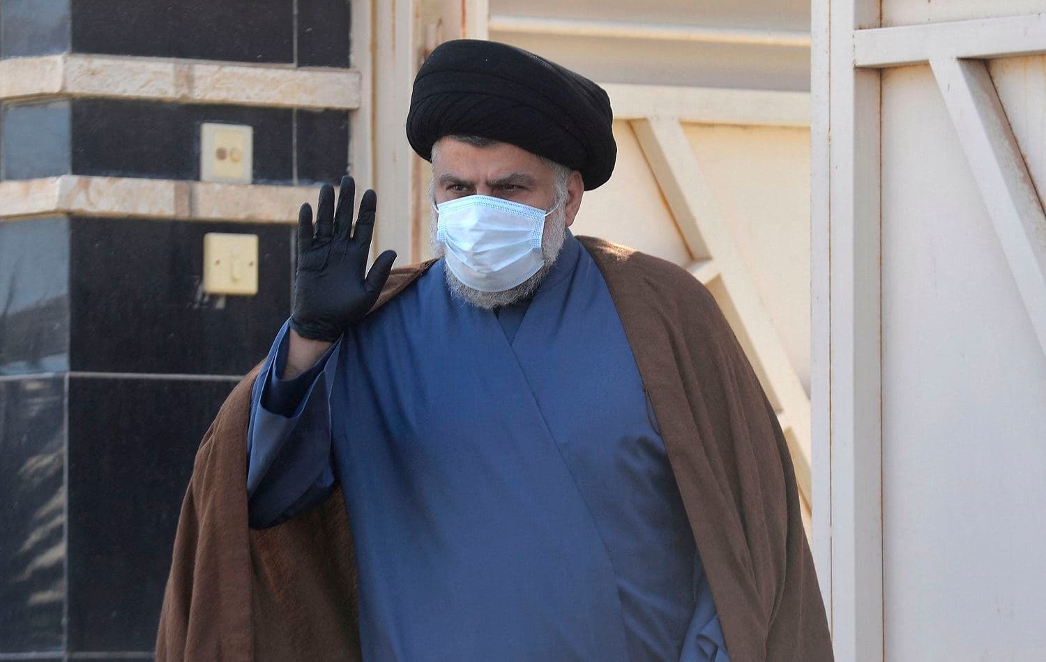 Iraqi cleric Muqtada al-Sadr waves outside his home in Iraq's holy city Najaf on February 10, 2021. Photo: Ali Najafi / AFP