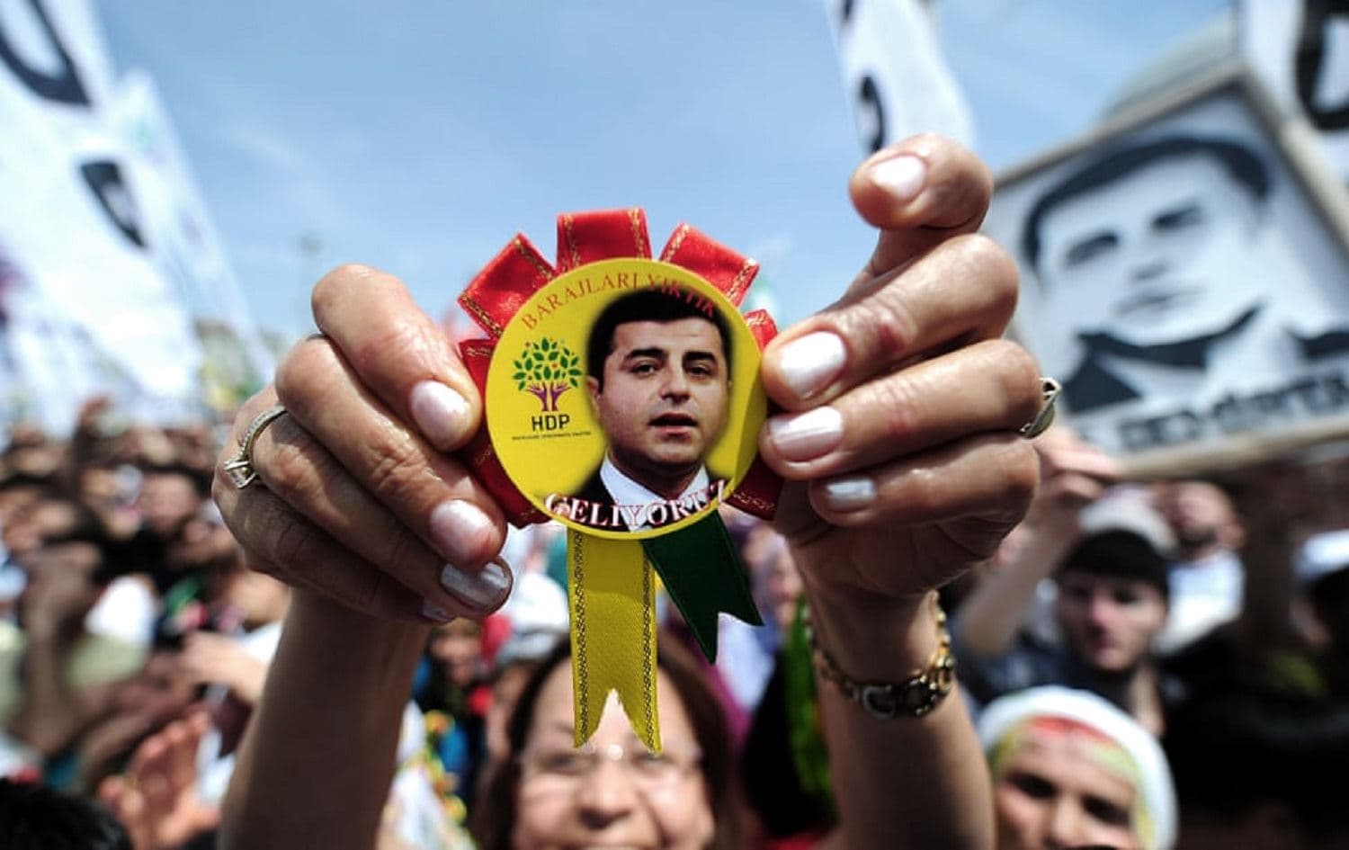 A woman shows a badge bearing the face of Selahattin Demirtas during a rally in 2015. Photo: Ozan Kose/AFP