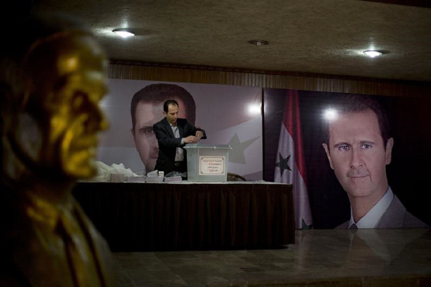 In this April 13, 2016 file photo, a Syrian election official waits for voters at a polling station with posters of President Bashar Assad during the parliamentary election in Damascus, Syria. Photo: AP