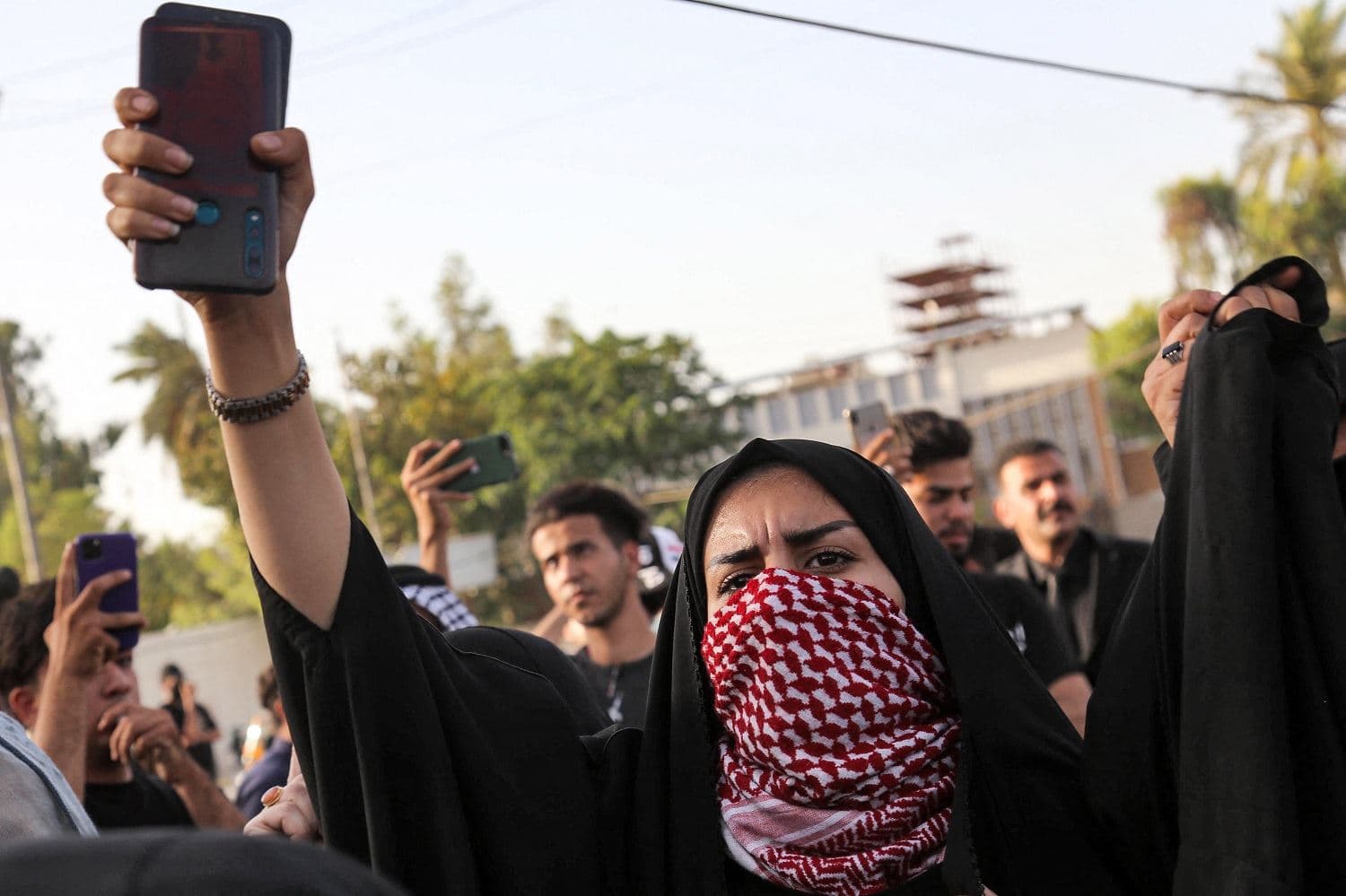 Mourners chant slogans as they march during a funerary procession for Iraqi activist Ihab al-Wazni in the central holy shrine city of Karbala on May 9, 2021. Photo: Mohammed Sawaf / AFP