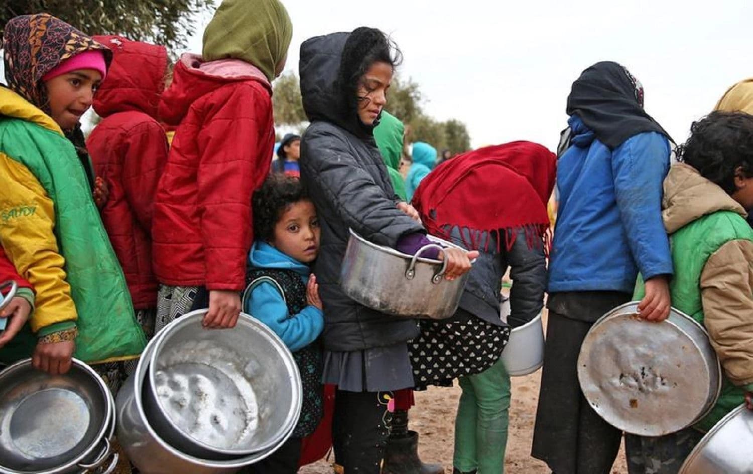 Syrian children queue to receive food distributed by aid workers at a makeshift camp for displaced people in northern Aleppo. Photo: Nazeer Al Khatib / AFP