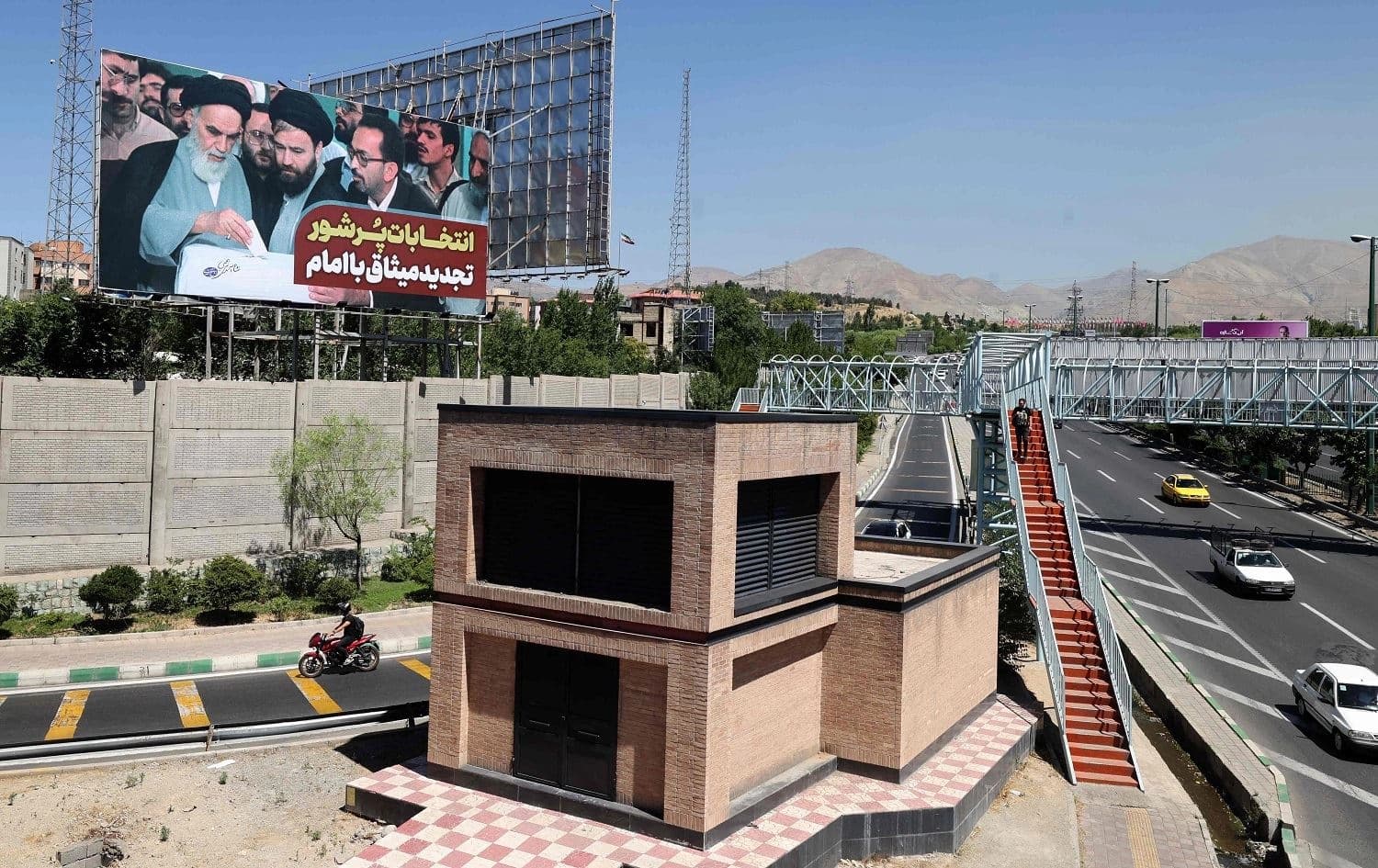 A billboard depicting the late founder of the Islamic Republic Ayatollah Ruhollah Khomeini casting a vote in a ballot box overlooks a highway in Iran's capital Tehran, on June 8, 2021, ahead of the June 18 presidential elections. Photo: Atta Kenare/AFP