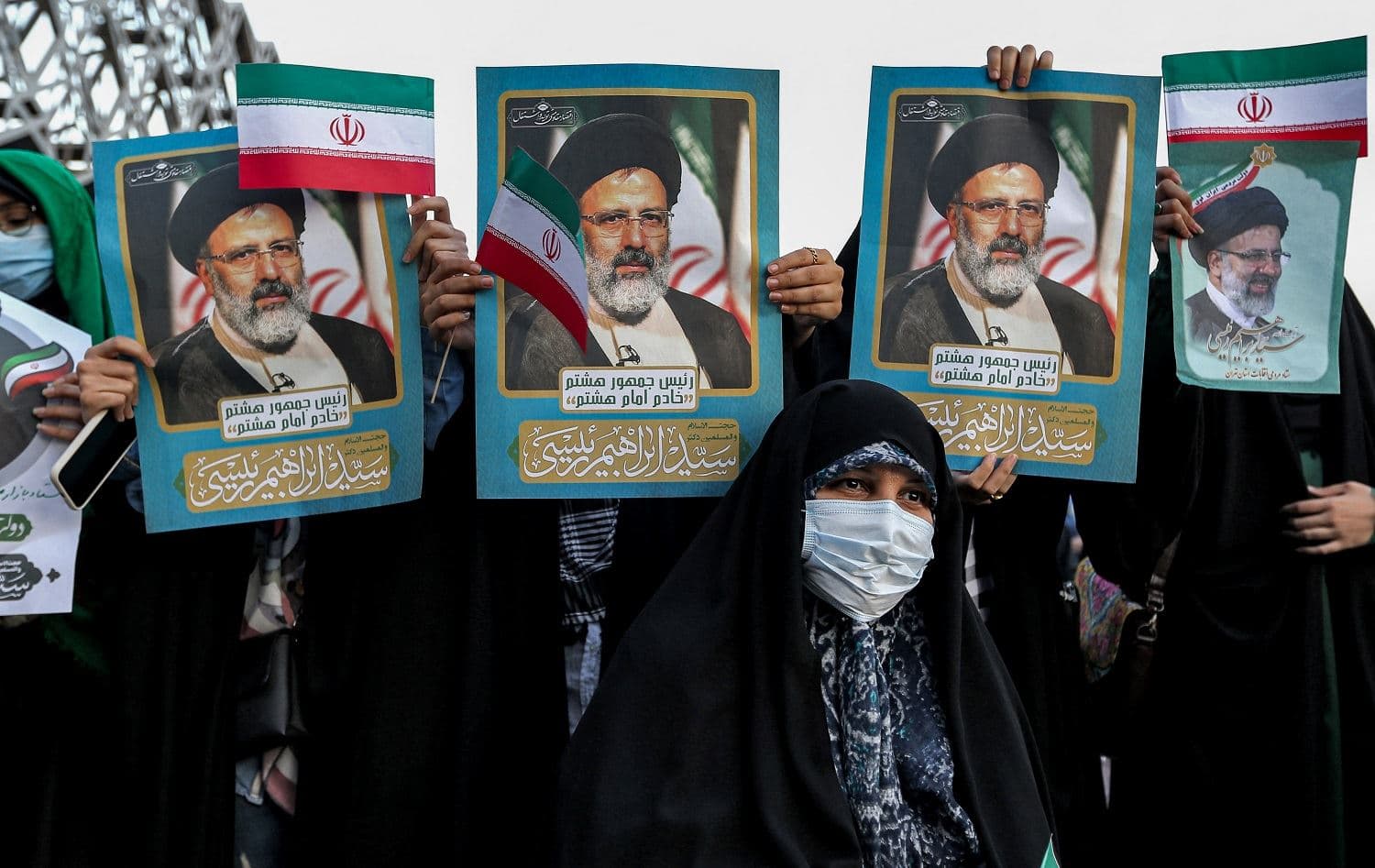 Supporters of Iran's newly-elected president Ebrahim Raisi hold posters depicting him as they celebrate his victory in Imam Hussein square in the capital Tehran on June 19, 2021. Photo: ATTA KENARE / AFP