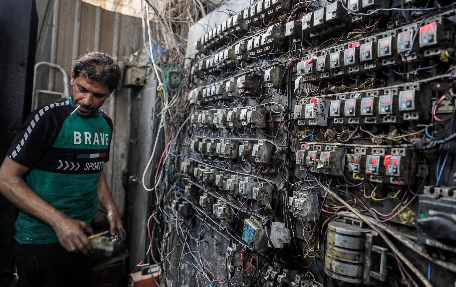 A technician monitors an electric switch board connecting homes to privately-owned generators in Baghdad on June 30, 2021. Photo: Ahmad al-Rubaye/AFP