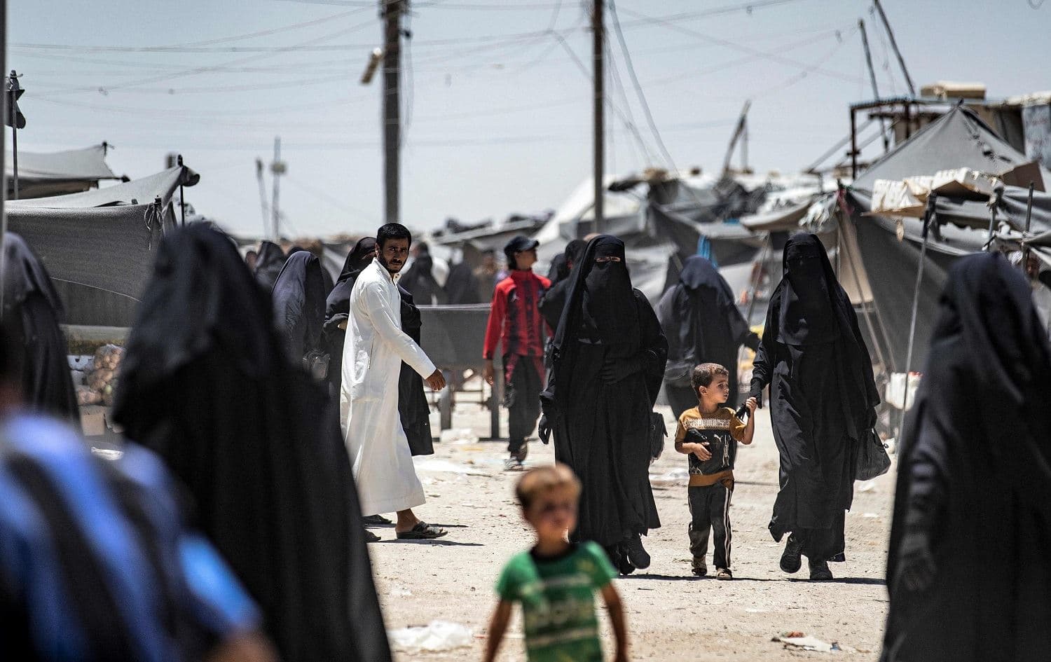 People walk in al-Hol camp, which holds relatives of suspected Islamic State (ISIS) group fighters, in Hasaka, northeastern Syria, on June 23, 2021. Photo: Delil Souleiman/AFP