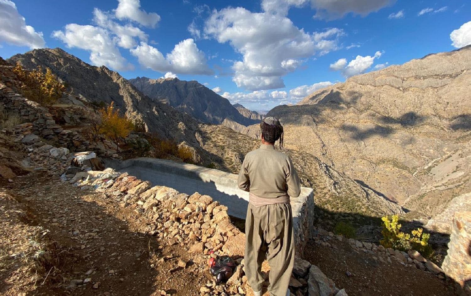 A man wearing traditional Kurdish clothing looks out over Hawraman Takht valley, in November 2020. Photo: Mohammed Bakhtiar