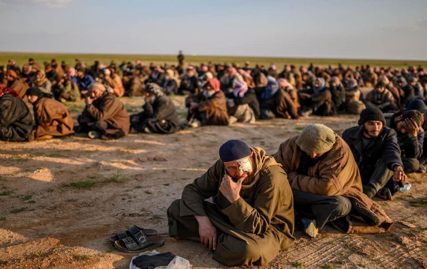 Suspected ISIS fighters wait to be searched by Kurdish forces. Photo: AFP