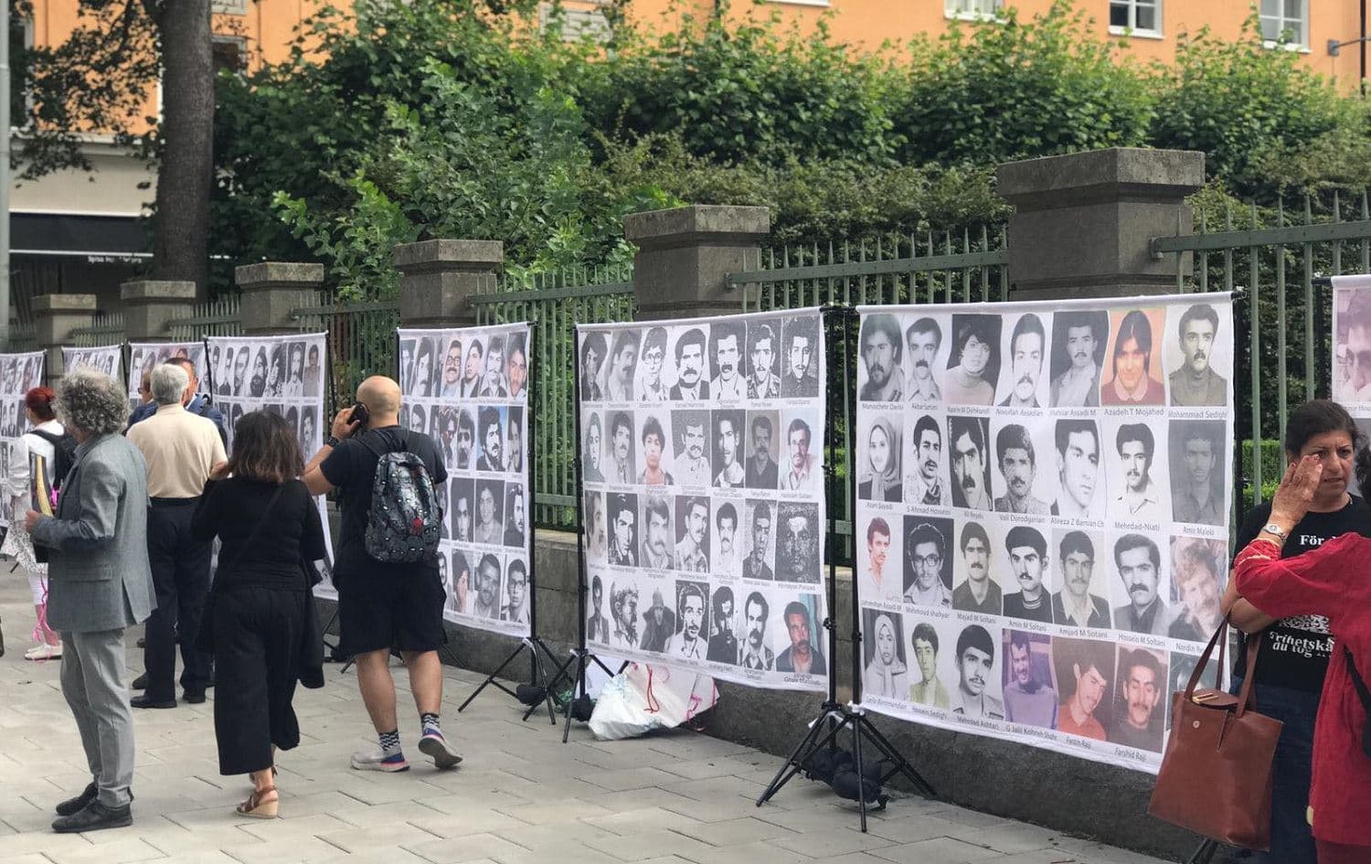 Photos of victims of Iran's 1988 prison massacre are displayed outside a Stockholm court house on August 10, 2021 where an Iranian national is on trial for war crimes in connection with the executions. Photo: Rebin Rahmani