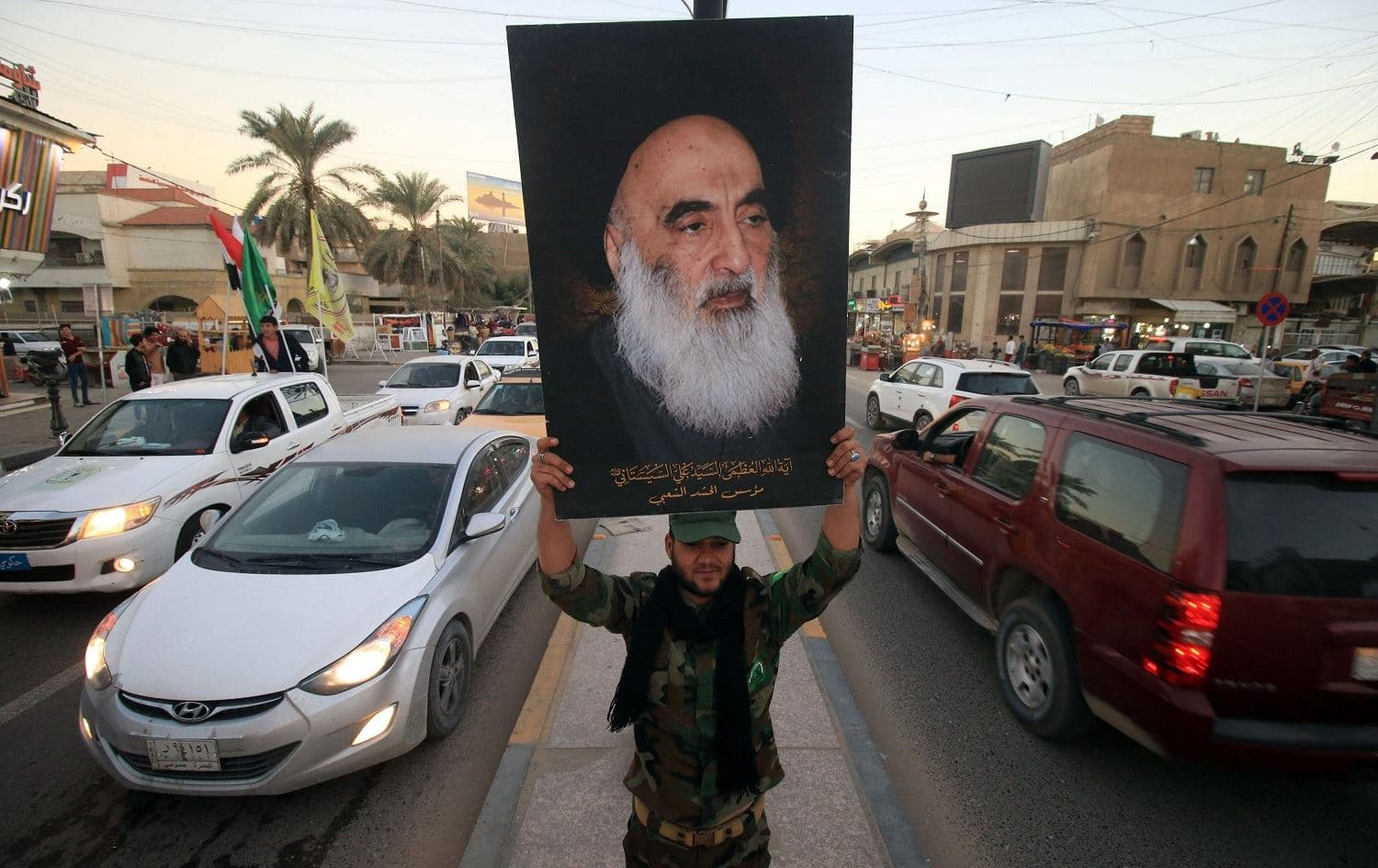 A member of Iraq's Popular Mobilization Forces (PMF) carries a portrait of Ayatollah Ali al-Sistani in Basra on December 10, 2017. File photo: AFP