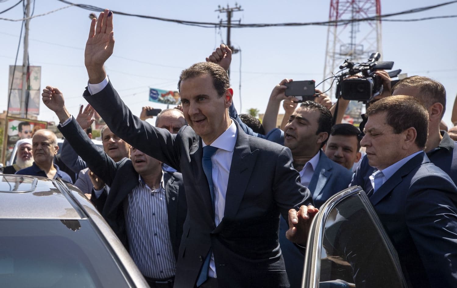 Syrian President Bashar Assad, right, waves for his supporters at a polling station during the Presidential elections in the town of Douma, near the Syrian capital Damascus on Wednesday, May 26, 2021. Photo: AP/Hassan Ammar