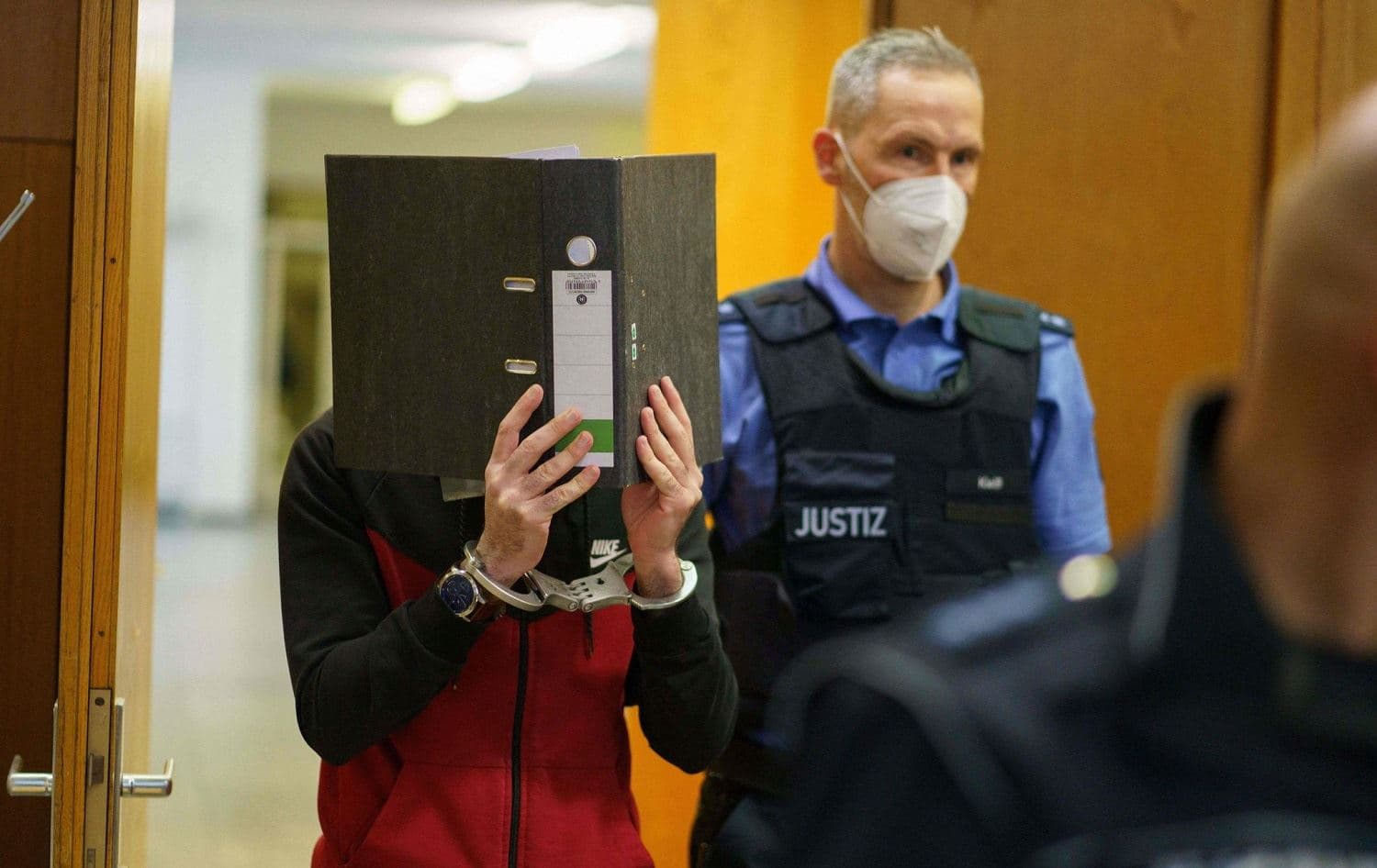 Taha Al-Jumailly (L) is led into the courtroom for the sentencing in his trial for charges of genocide, crimes against humanity, war crimes, human trafficking and murder in Frankfurt, western Germany, on November 30, 2021. Photo: Frank Rumpenhorst / AFP