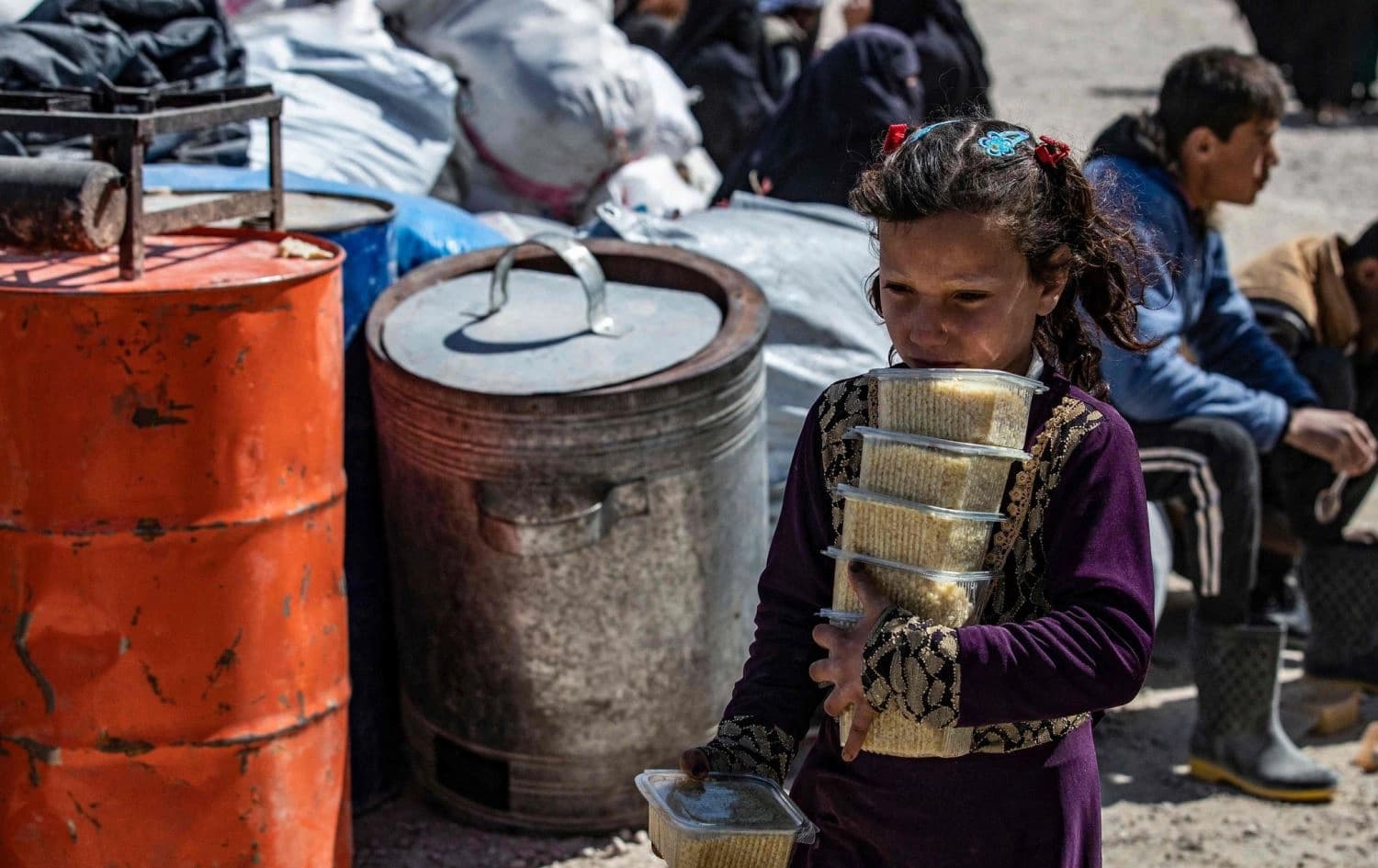 A little girl carrying food in al-Hol camp on March 18, 2021. Photo: AFP