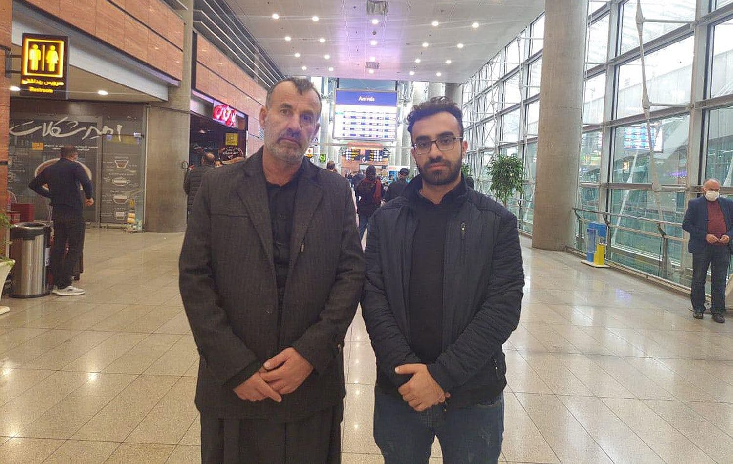 Sirwan Alipour's father Abubakir Alipour (left) and his brother Saman Alipour (right) at Tehran's Imam Khomeini Airport awaiting the arrival of Sirwan's body from France on December 20, 2021. Photo: Submitted
