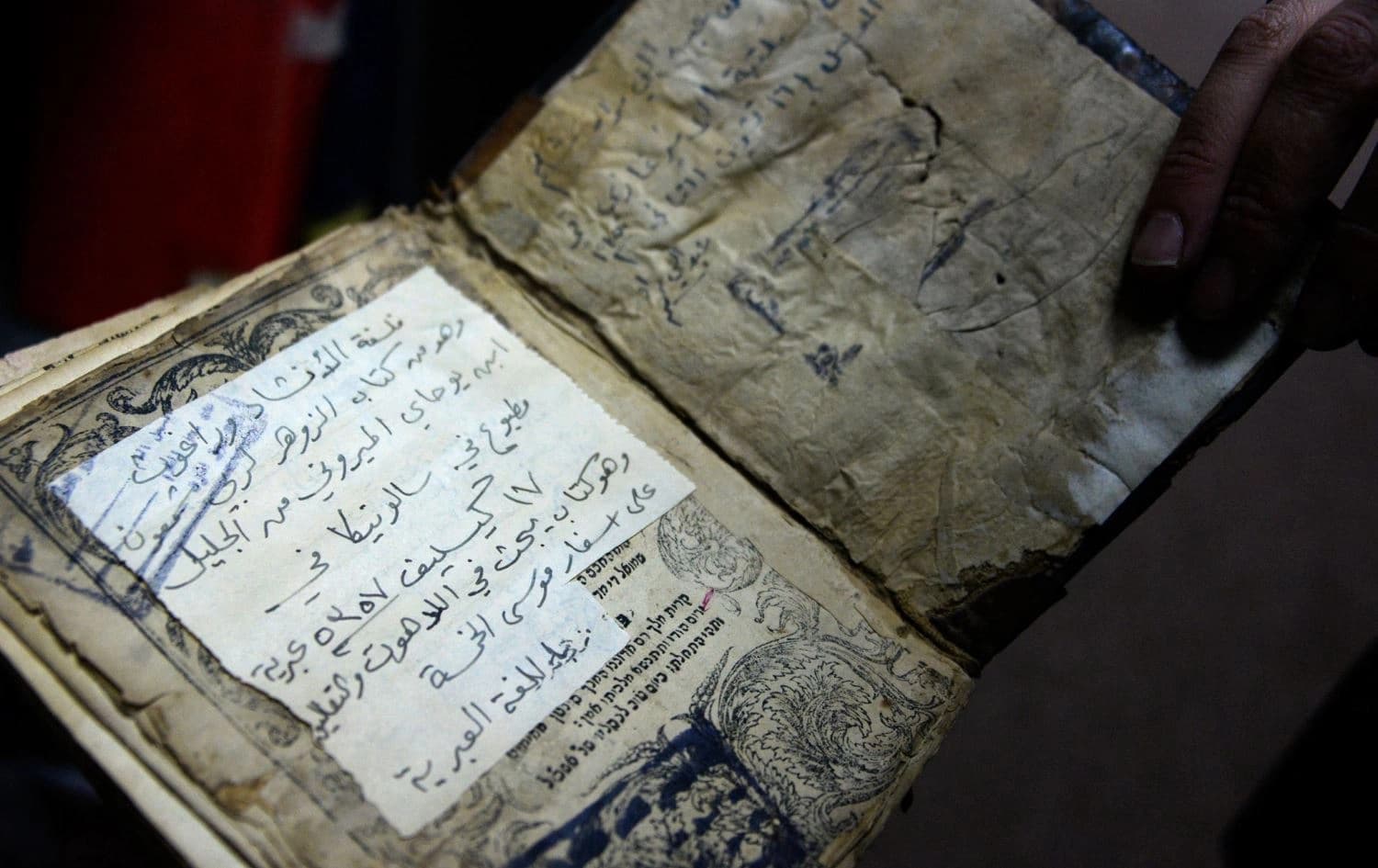 A librarian shows a book from the library collection of the University of Iraq's northern city of Mosul, on January 31, 2022. Photo: Zaid Al-Obeidi/AFP