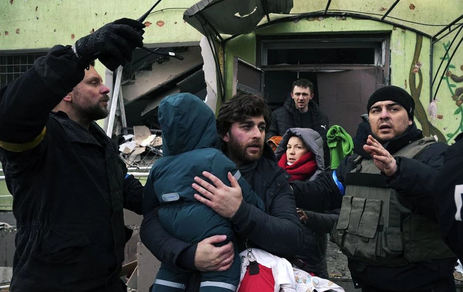 A man carries his child away from the damaged by shelling maternity hospital in Mariupol, Ukraine, on March 9, 2022. Photo: Evgeniy Maloletka/AP