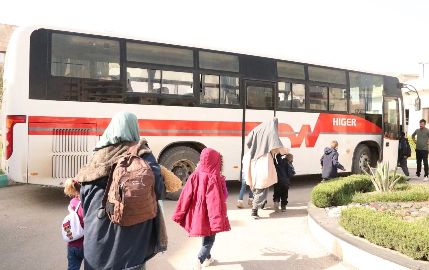 ISIS-affiliated German women and their children enter a bus in an unidentified location in Rojava on March 30, 2022. Photo: ANHA