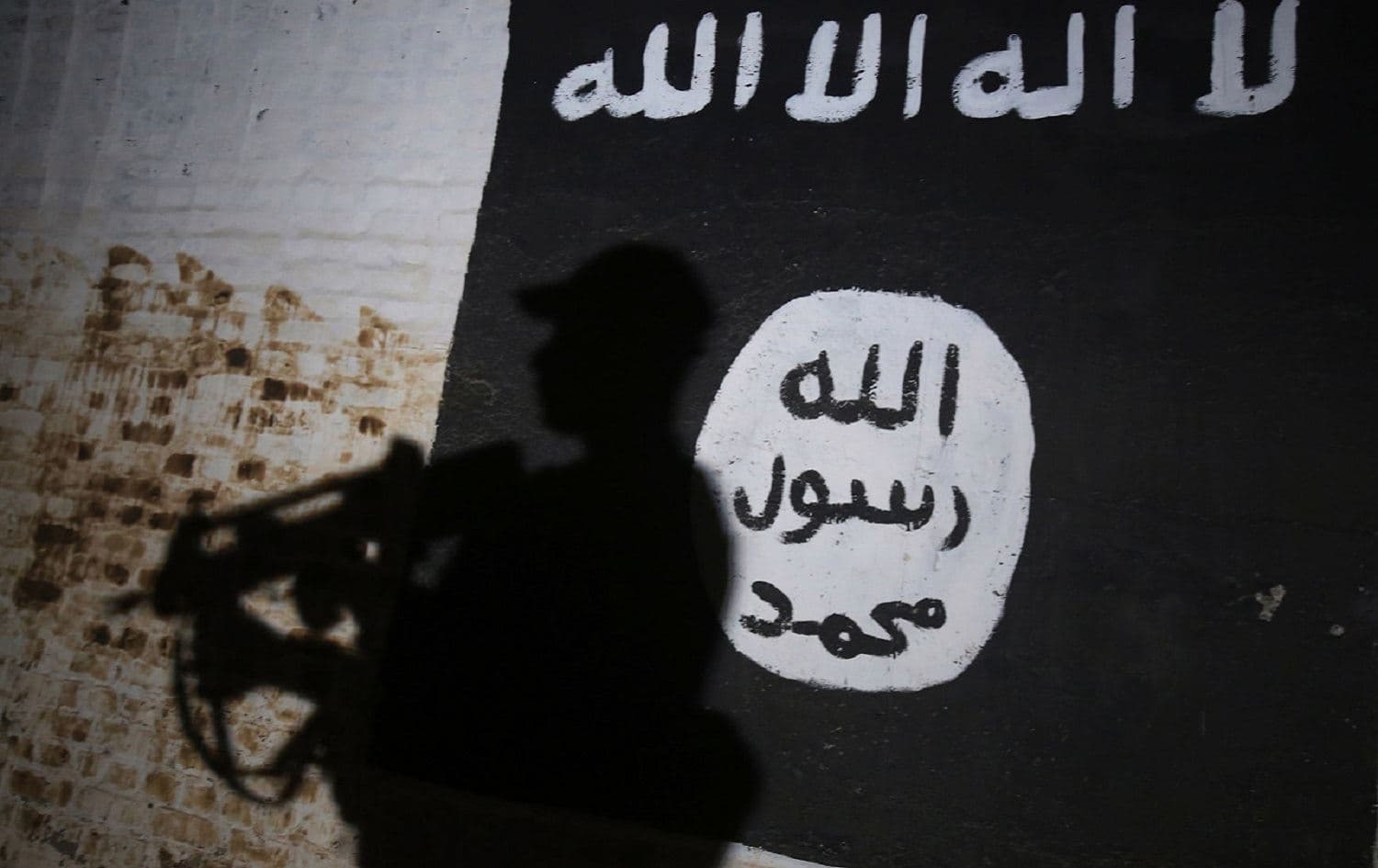 A member of the Iraqi Security Forces (ISF) walks past a mural bearing the Islamic State (ISIS) logo in Albu Sayf. File photo: AFP