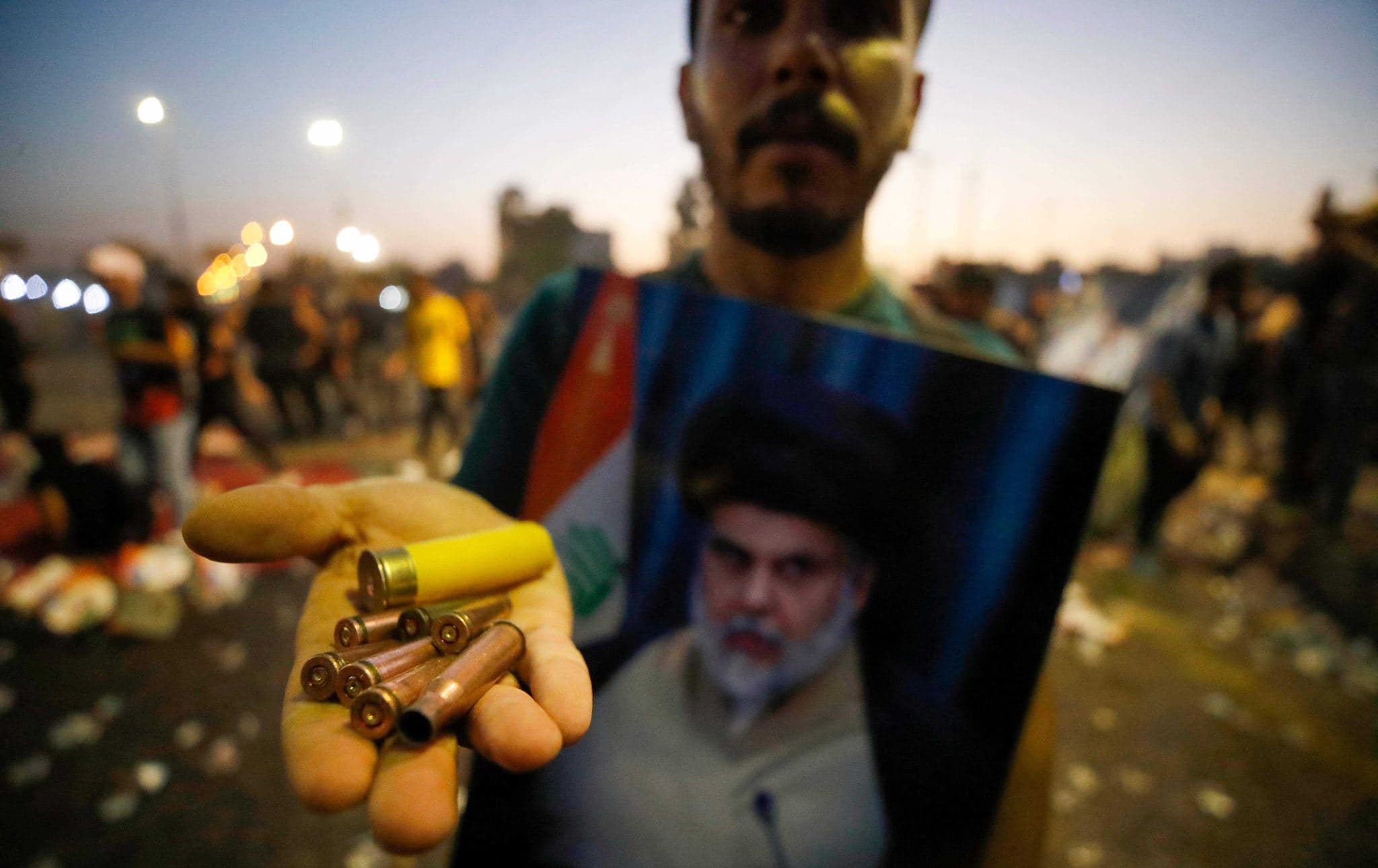 A supporter of Iraqi Shiite cleric Moqtada Sadr carries bullet casings and a spent shotgun shell in the capital Baghdad, on August 29, 2022. Photo: Ahmad al-Rubaye/AFP