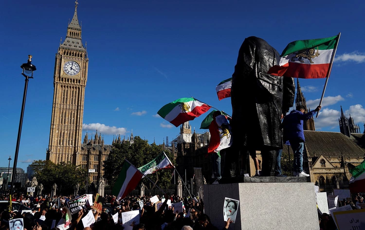 People wave flags and hold placards during a protest following the death of Mahsa Amini who died in custody of Iran's morality police, in central London on October 8, 2022. Photo: Niklas Halle’n/AFP
