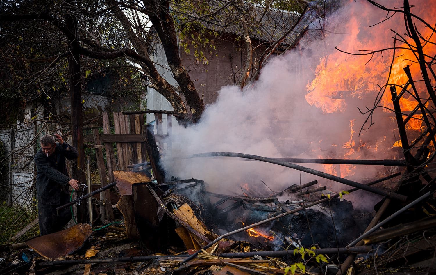 A local resident works to extinguish a fire after shelling in the town of Bakhmut, in eastern Ukraine's Donbas region, on October 23, 2022, amid Russia's military invasion on Ukraine. Photo: AFP