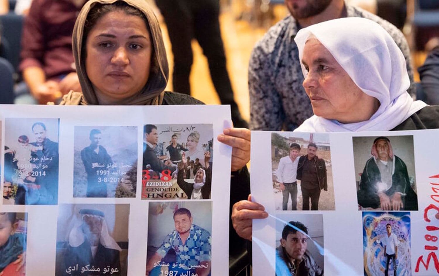 Yazidi women hold up pictures of missed relatives during a commemoration ceremony in Germany. File photo: AFP.