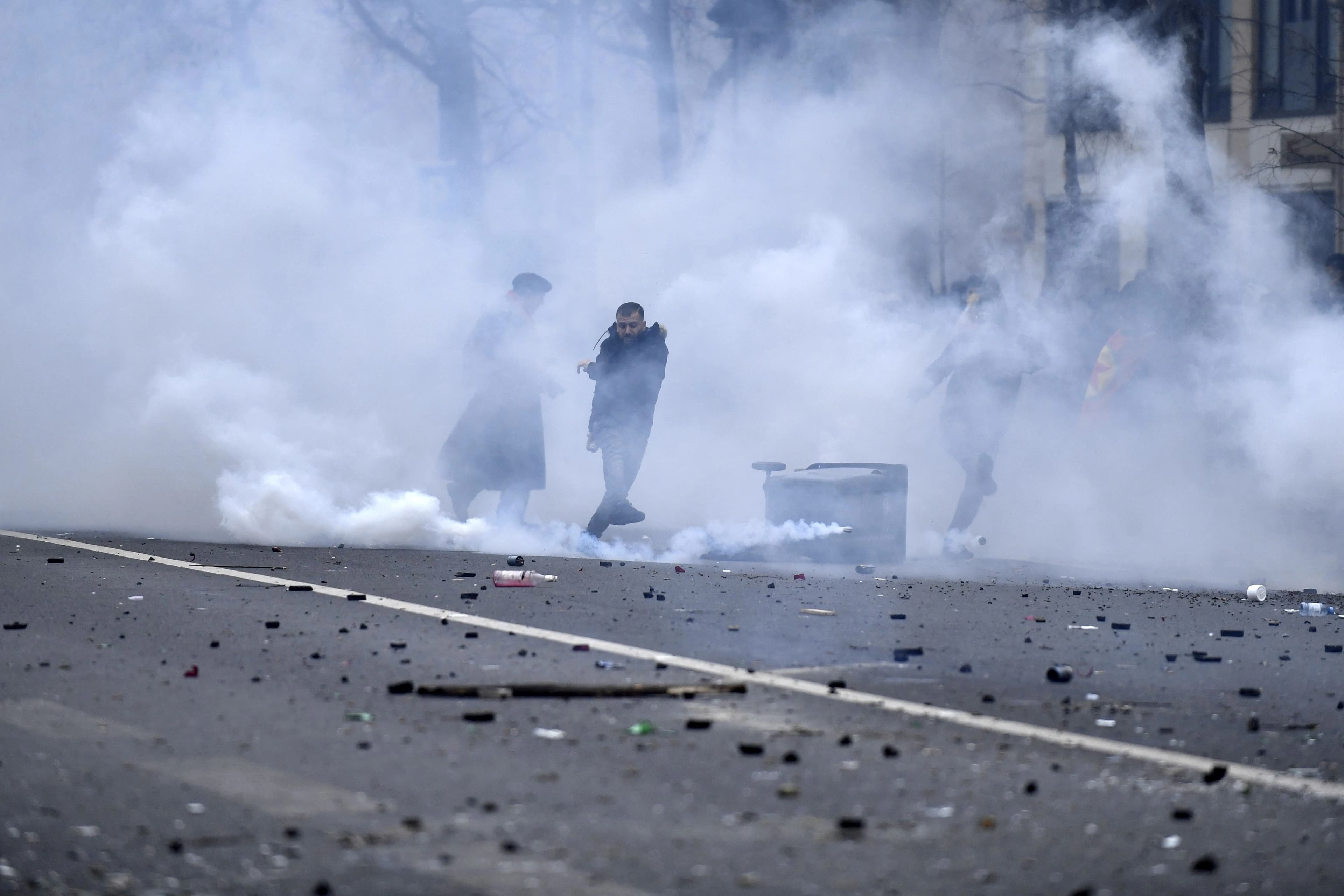 Protesters stand amid tear gas smoke during clashes following a demonstration of members of the Kurdish community, a day after a gunman opened fire at a Kurdish cultural centre killing three people, at The Place de la Republique in Paris on December 24, 2022. Photo: AFP