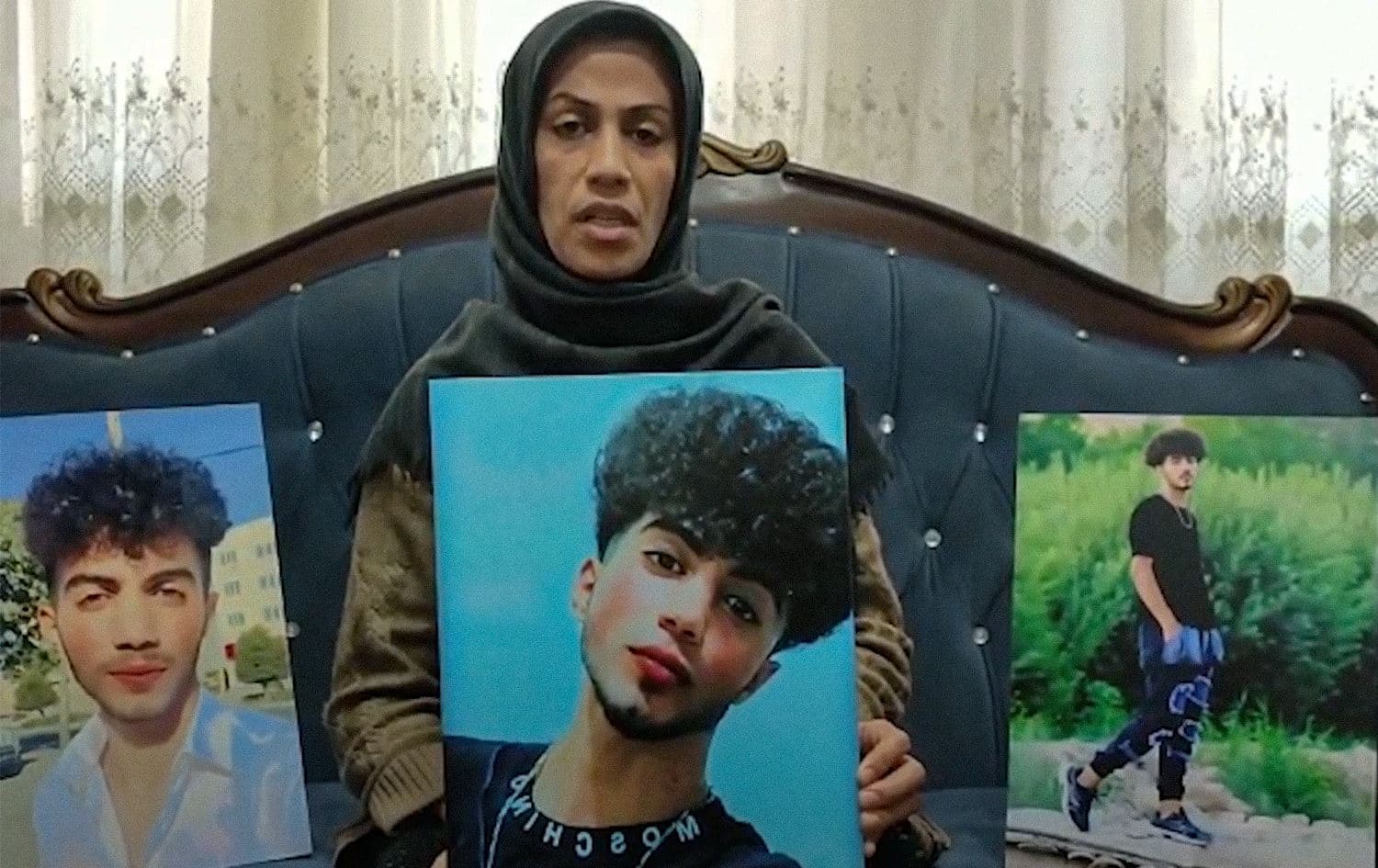 Parvin Shafaqdoost holding up pictures of her 17-year-old son Nima who was killed during the protests in Urmia in September. Photo: KHRN