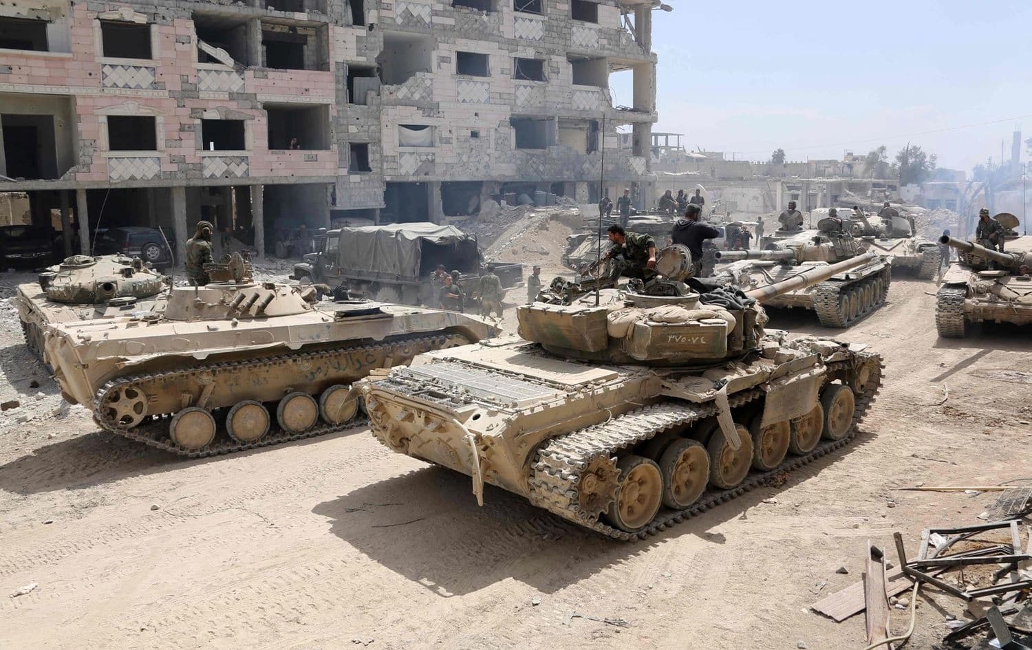 Syrian Army soldiers gather Sunday in an area on the eastern outskirts of Douma as they continue their force offensive to retake the last opposition holdout in eastern Ghouta. Photo: AFP