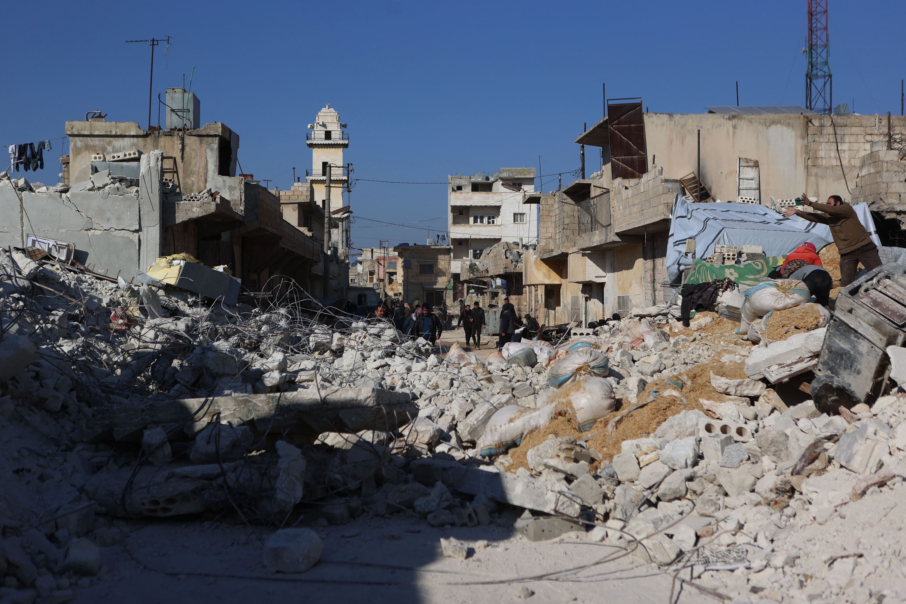 Syrians walk amidst the rubble of collapsed buildings following last week's earthquake in Syria's rebel-held village of Atarib, in the northwestern Aleppo province, on February 14, 2023. Photo: AFP