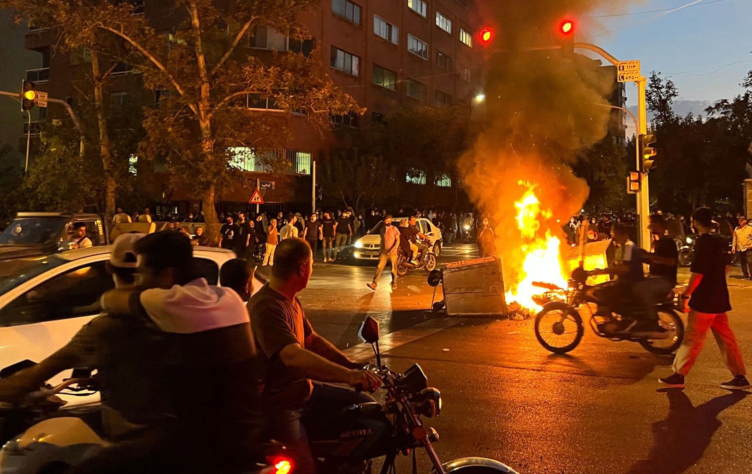 Demonstrators gather around a burning barricade during a protest for Zhina Amini in Tehran on September 19, 2022. Photo: AFP