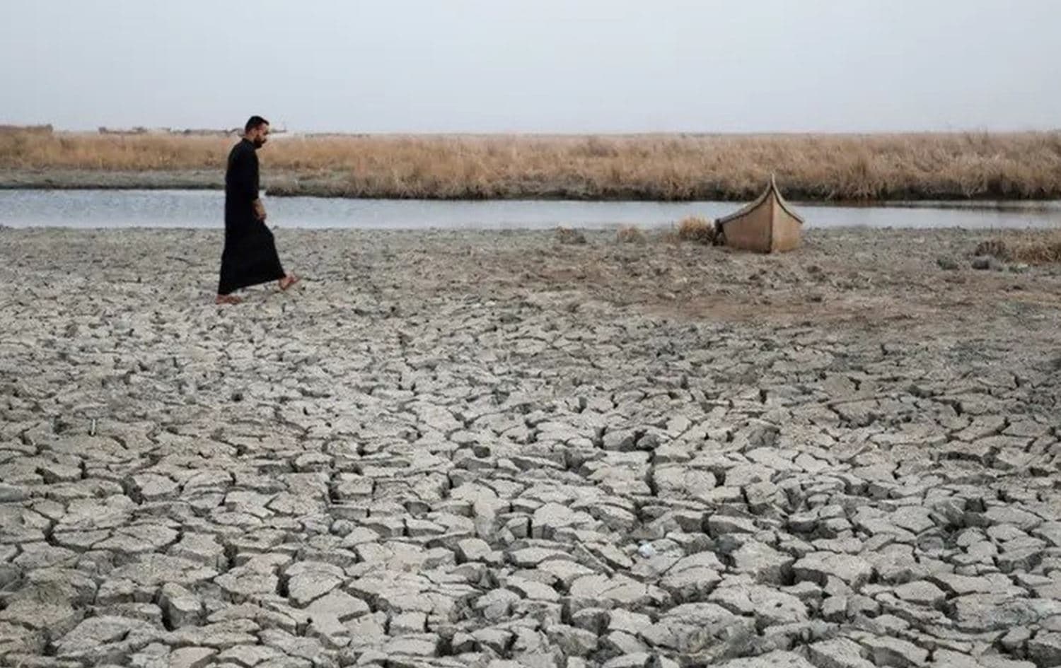 A demonstrator approaches a boat stuck in the dried-up bank of a canal, during a rally at the Umm El Wadaa marsh, south-east of the Iraqi city of Nasiriyah in the southern Dhi Qar province, on August 16, 2022, to demand solutions for water scarcity and drought. Photo: AFP