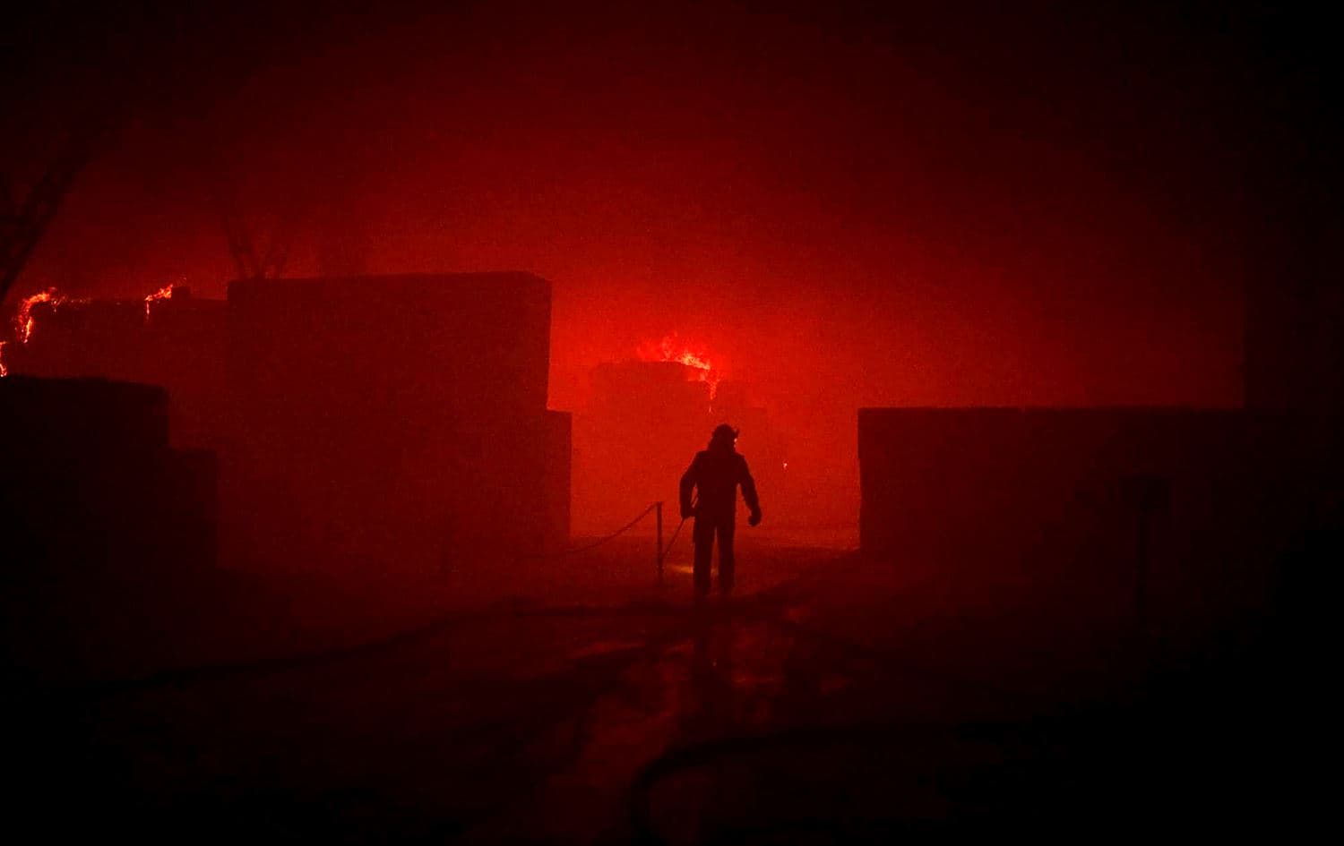A rescuer putting out a fire in a building as a result of falling debris after a massive drone attack mainly targeting the Ukrainian capital Kyiv on May 28, 2023. Photo: Pavlo Petrov/State Emergency Service of Ukraine/AFP