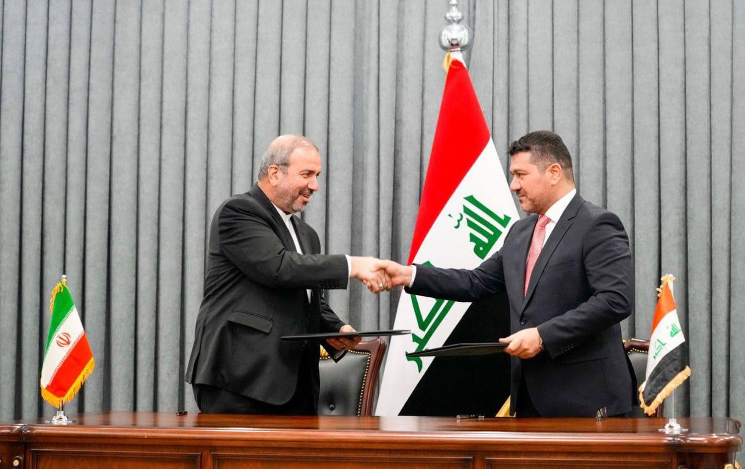Director of the Iraqi prime minister’s office Ihsan Yassin al-Awadi (right), and Iran's ambassador to Iraq Mohammad Kazem Al-e Sadeq (left) sign an agreement to exchange Iraqi oil for Iranian gas on July 11, 2023. Photo: PM Sudani's office