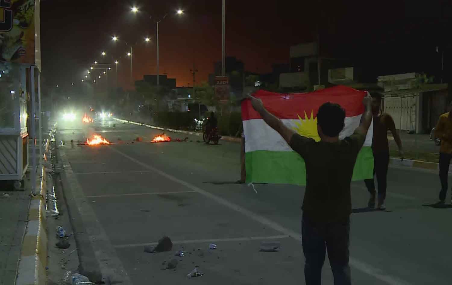 Kurdish youth in Kirkuk hold up the Kurdistan flag while protesting against the closure of the Kirkuk-Erbil road and the killing of a Kurdish citizen in Kirkuk as tensions surge between Kurdish, Arab, and Turkmen components of the city on September 2, 2023. Photo: Rudaw