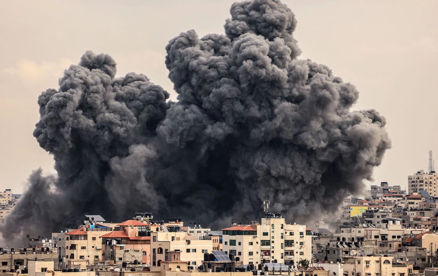 A plume of smoke rises in the sky of Gaza City during an Israeli airstrike on October 9, 2023. Photo: Mahmud Hams/AFP