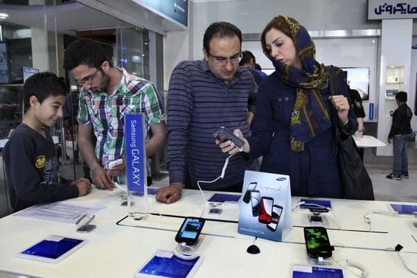 کڕیاران لەکاتی تاقیکردنەوەی مۆبایلی سامسۆنگ لە فرۆشگەیەکی تاران، وێنە: AP