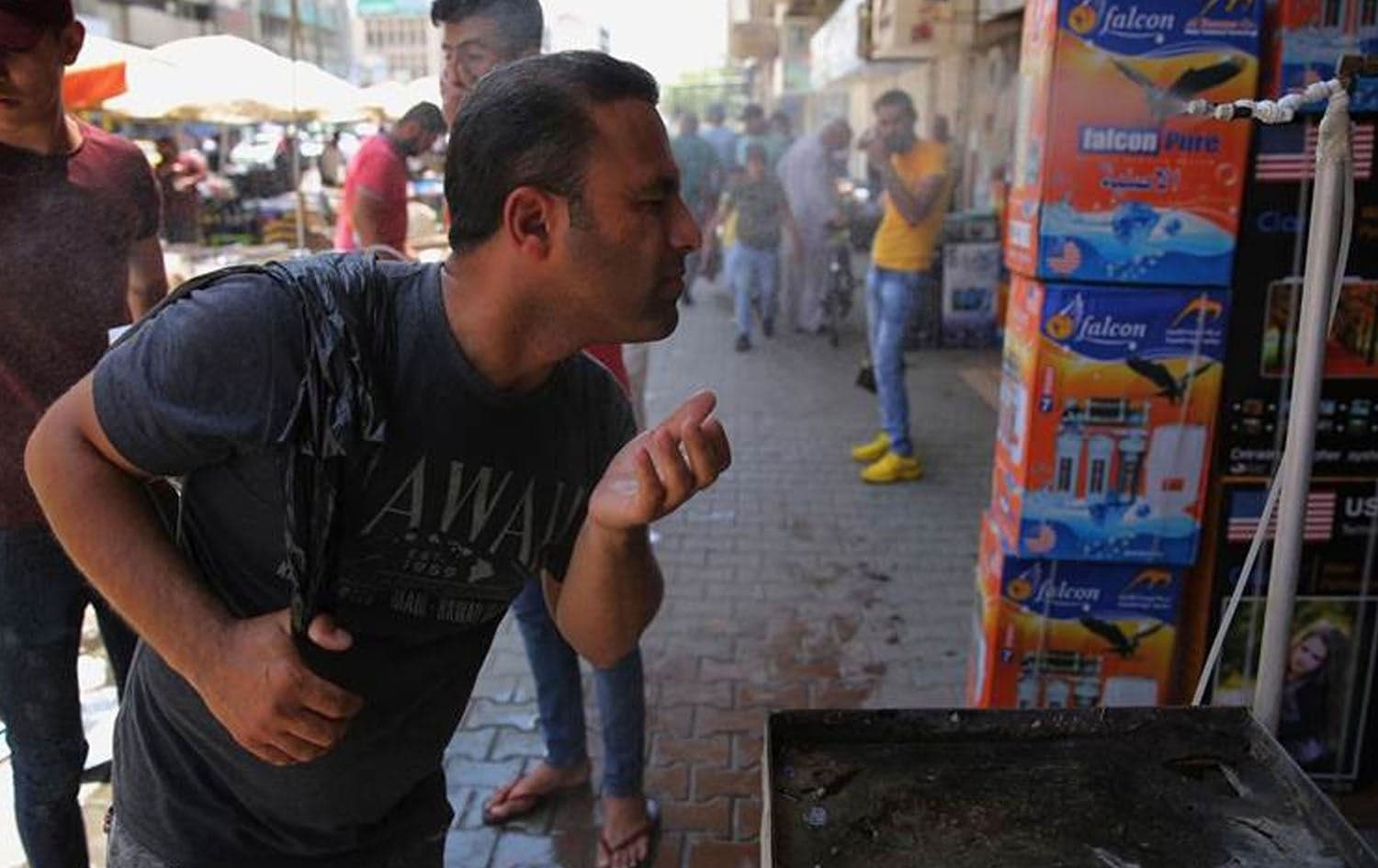 An Iraqi man uses a curbside shower to cool off during a heat wave in the capital Baghdad in June, 2019. Photo: AFP